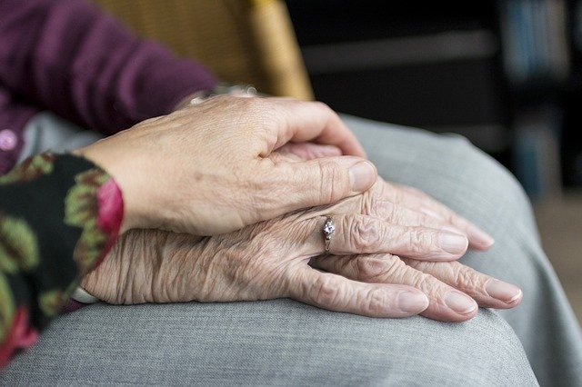 old person's hand on another old person's hand